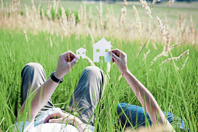 Couple Laying in Grassy Field Holding Flowers