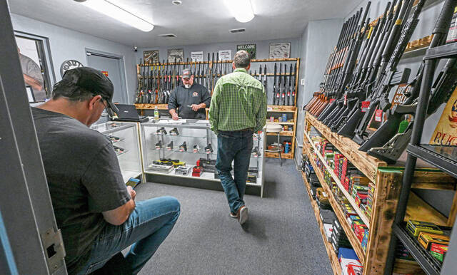 Co-owner of RC Firearms Roy Berg files paperwork of transferring a gun Jan. 17 at his shop in New Kensington.